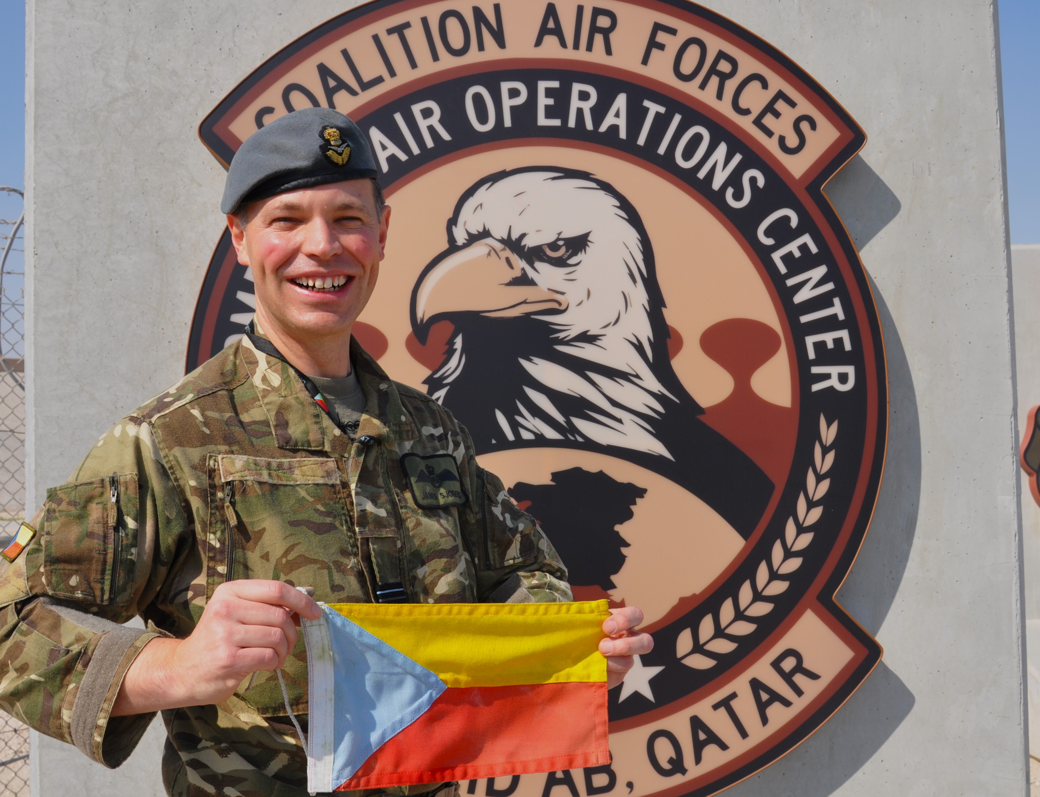 Wing Commander James Sjoberg, currently deployed as COS Ops at 83 EAG on OP Shader, with the 47 Squadron tricolour flag.